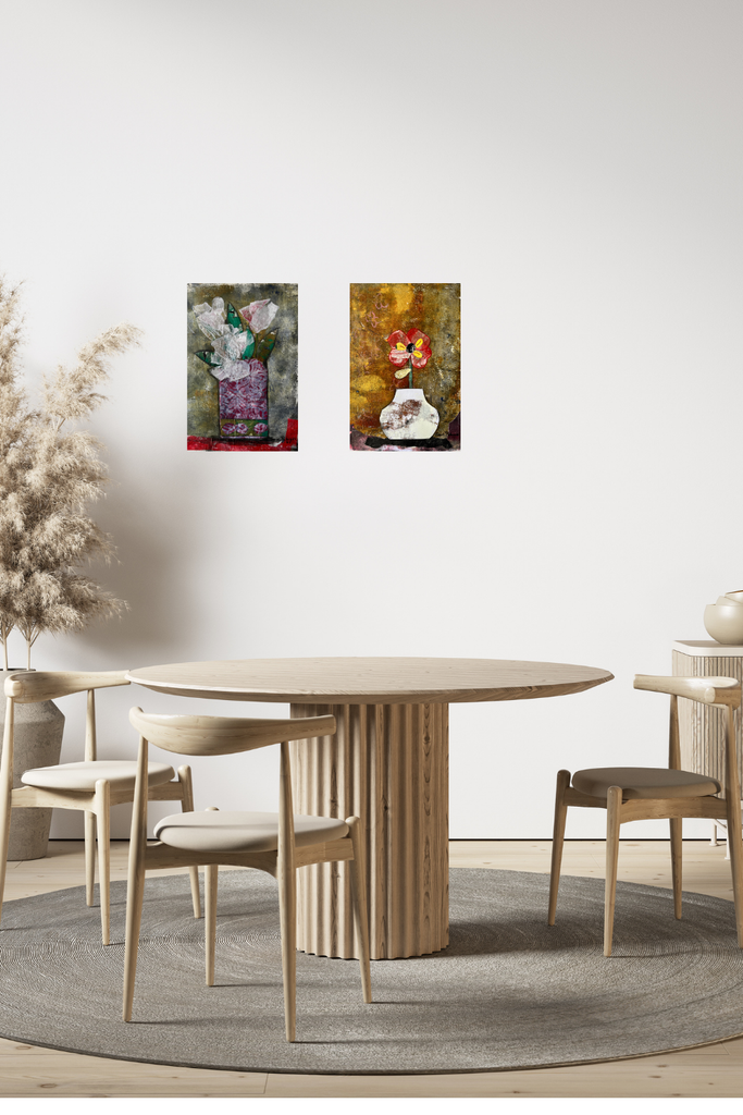 Dining area with a round wooden table and chairs, featuring two wall-mounted artworks.