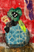 Collage art with a blue vase, green flower, and black dots on a textured red background