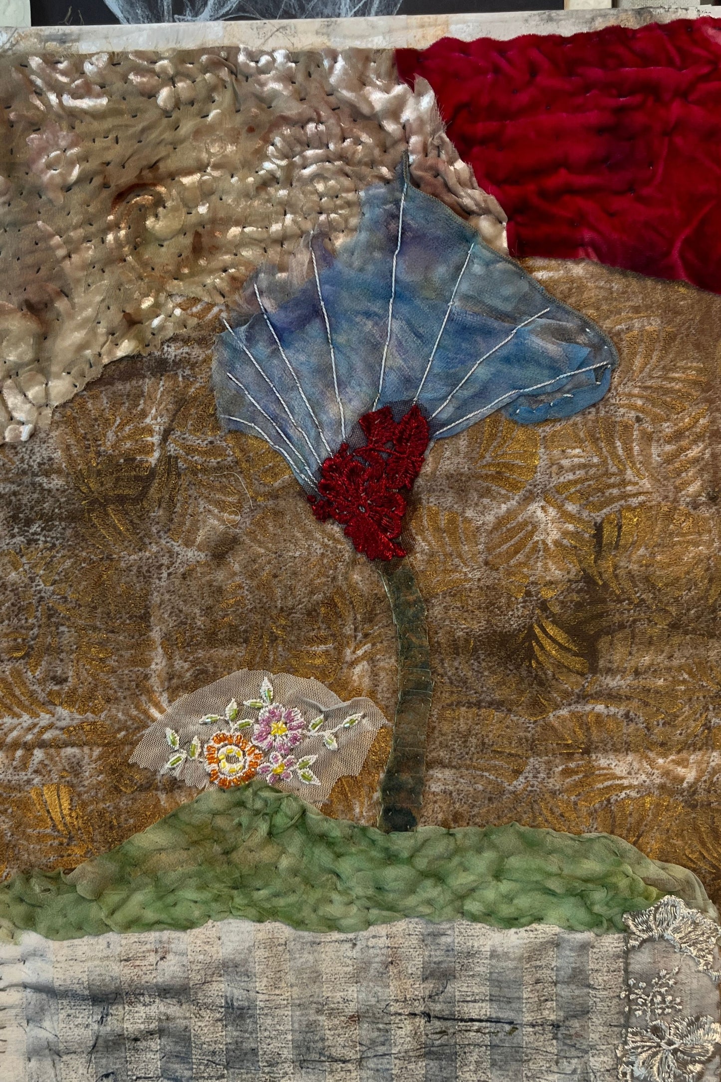 Textile art piece with floral design and textured background