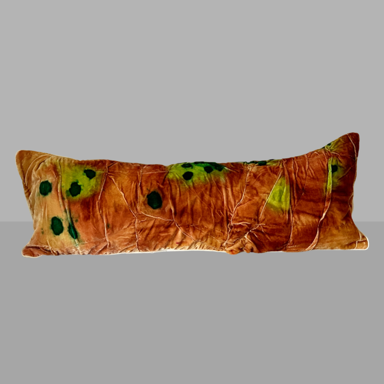 Decorative pillow with brown and green pattern on a gray background