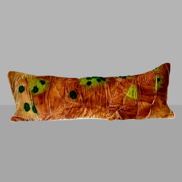 Decorative pillow with brown and green pattern on a gray background