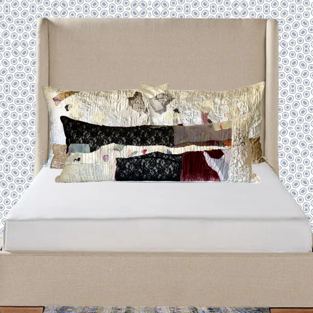 Bed with decorative pillows against a patterned wall