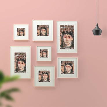 Set of framed portraits on a pink wall