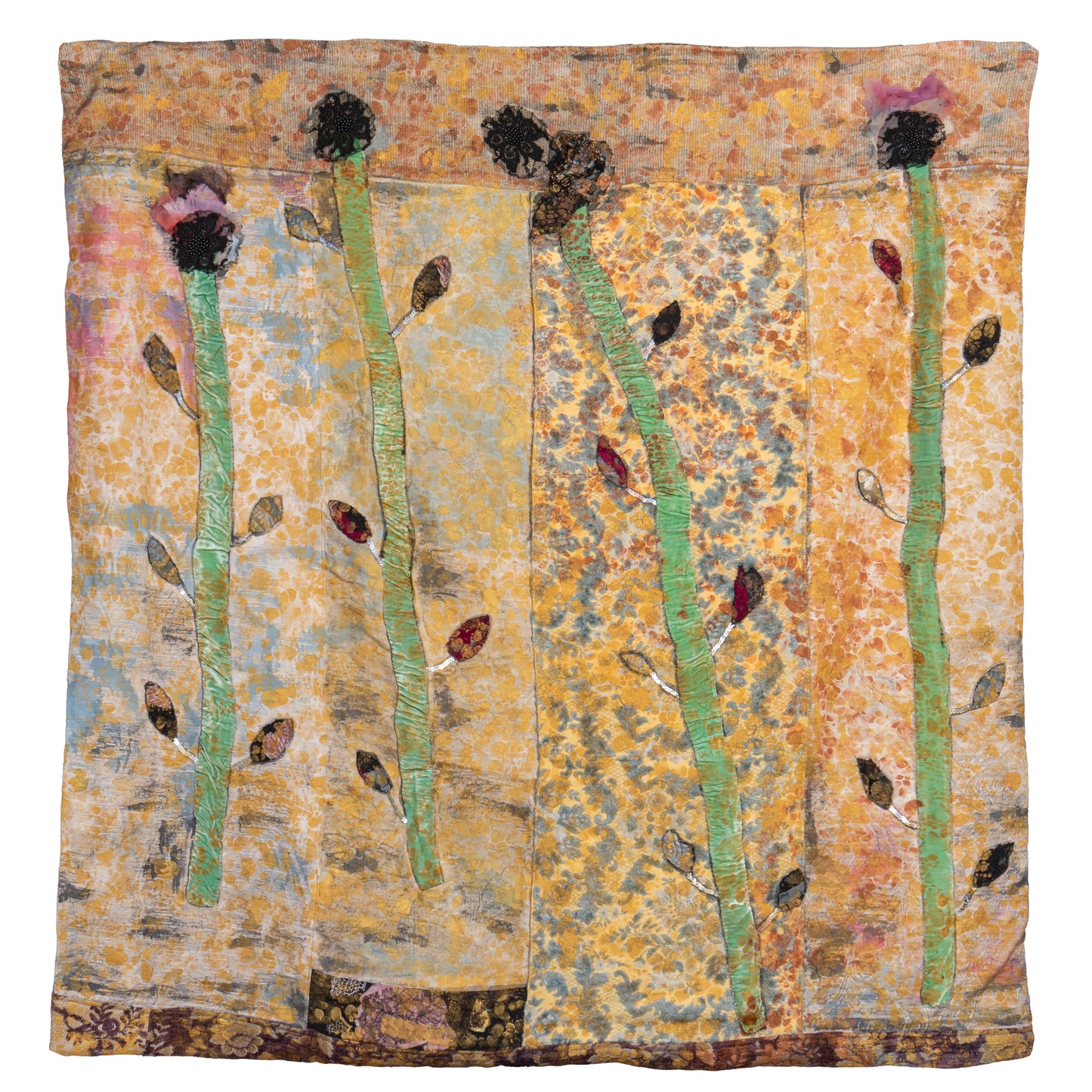 A square textile art piece featuring four tall green stems with dark seed heads and small brown and red leaves, set against a mottled background of gold, orange, and blue tones.