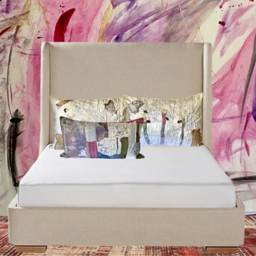 Beige bed with decorative pillows against a colorful abstract wall.