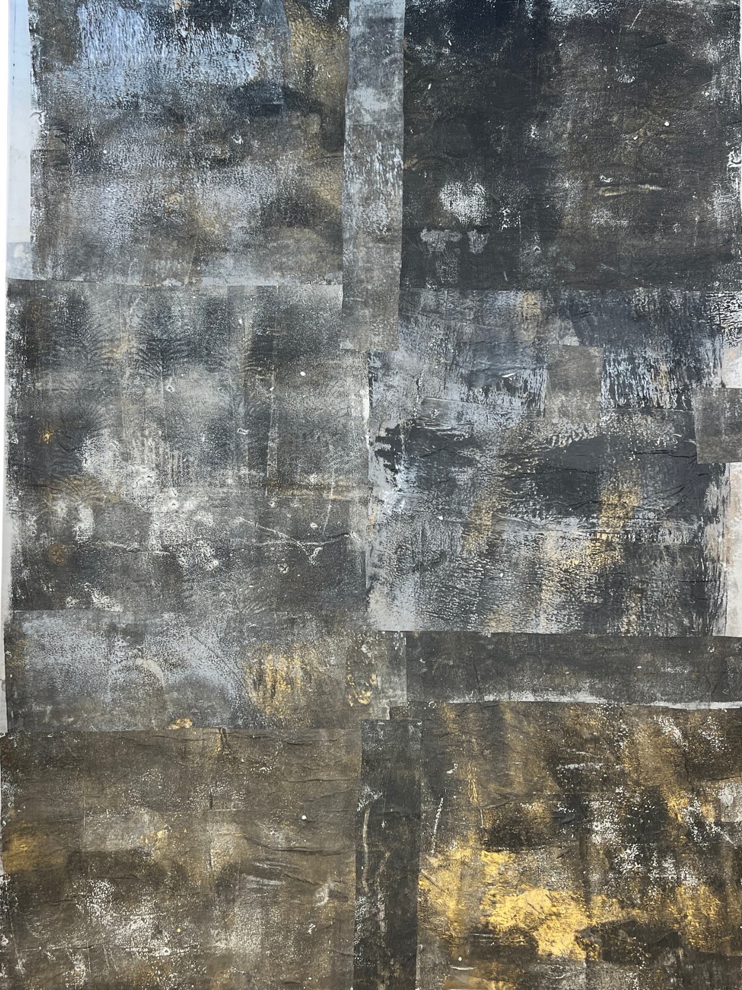 Abstract art piece with a patchwork of black, gray, and gold colors.