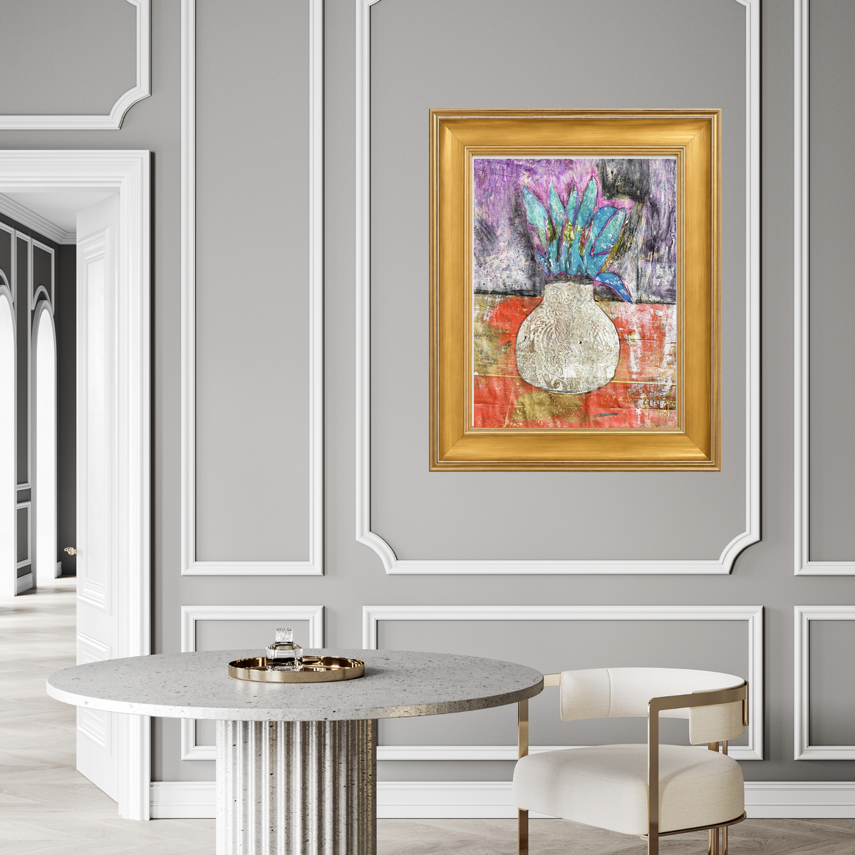 Corn Moon fine art print by Sara Palacios displayed in a gold frame on a gray paneled wall above a round marble dining table in an elegant, light-filled room.