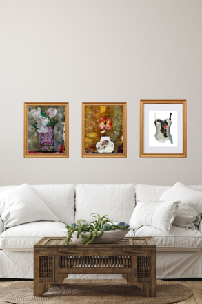 Three framed artworks on a wall above a white sofa with a wooden coffee table.