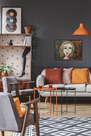 Portrait of a woman named Regina with red lips, expressive eyes, and textured black-and-red collage hair, against a dark painted background.
