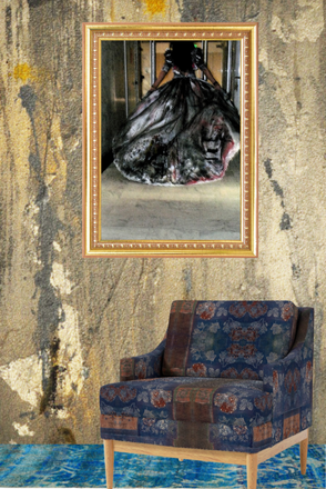 Framed artwork of a woman in a black dress on a textured wall with a patterned chair below.