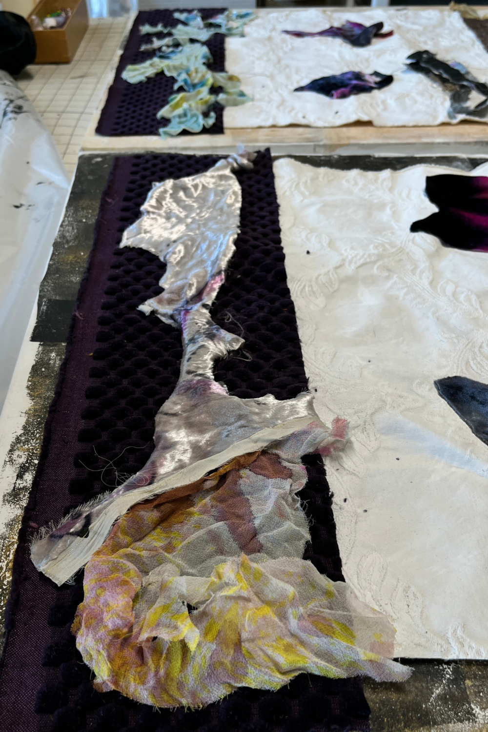 Textile art piece with various patterns and colors on a table.