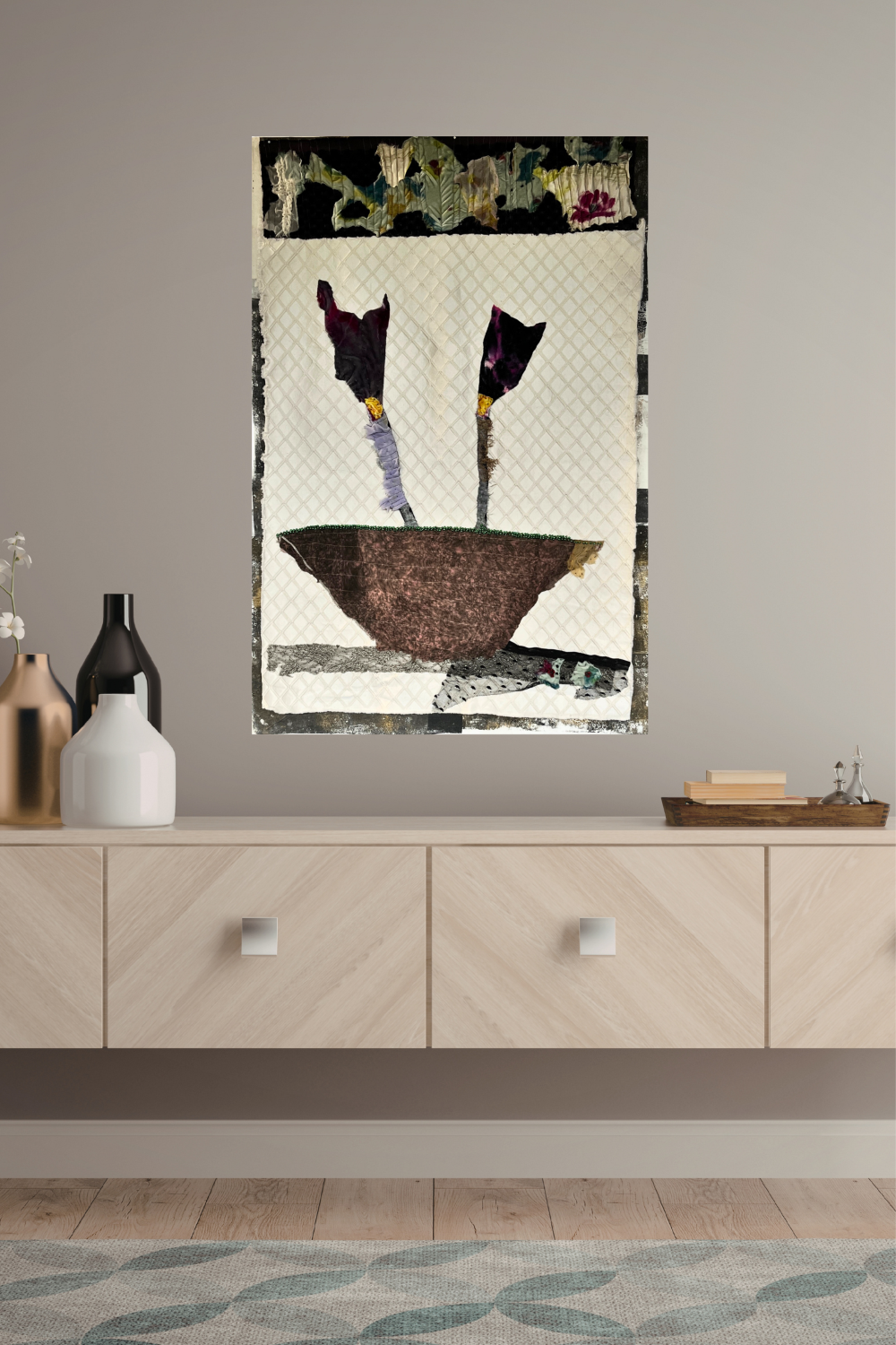 Abstract art piece on a wall above a wooden cabinet with decorative items.