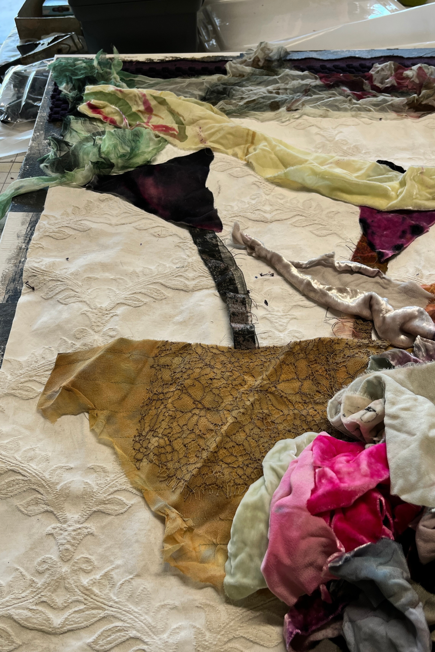 Textile art piece with various fabrics and patterns on a flat surface