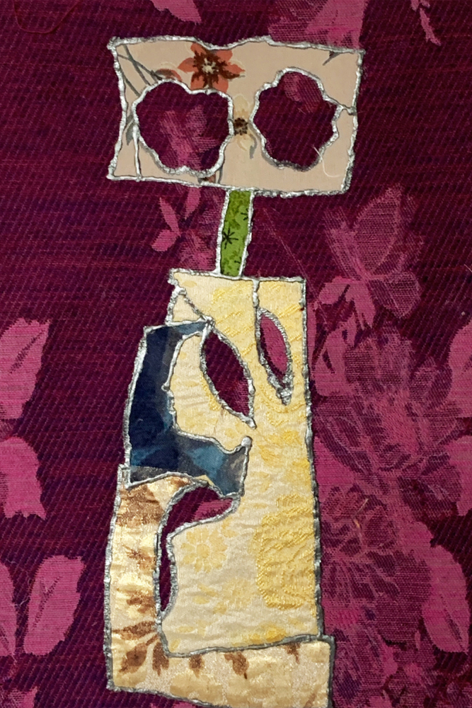 Textile art piece with floral design on a textured fabric background