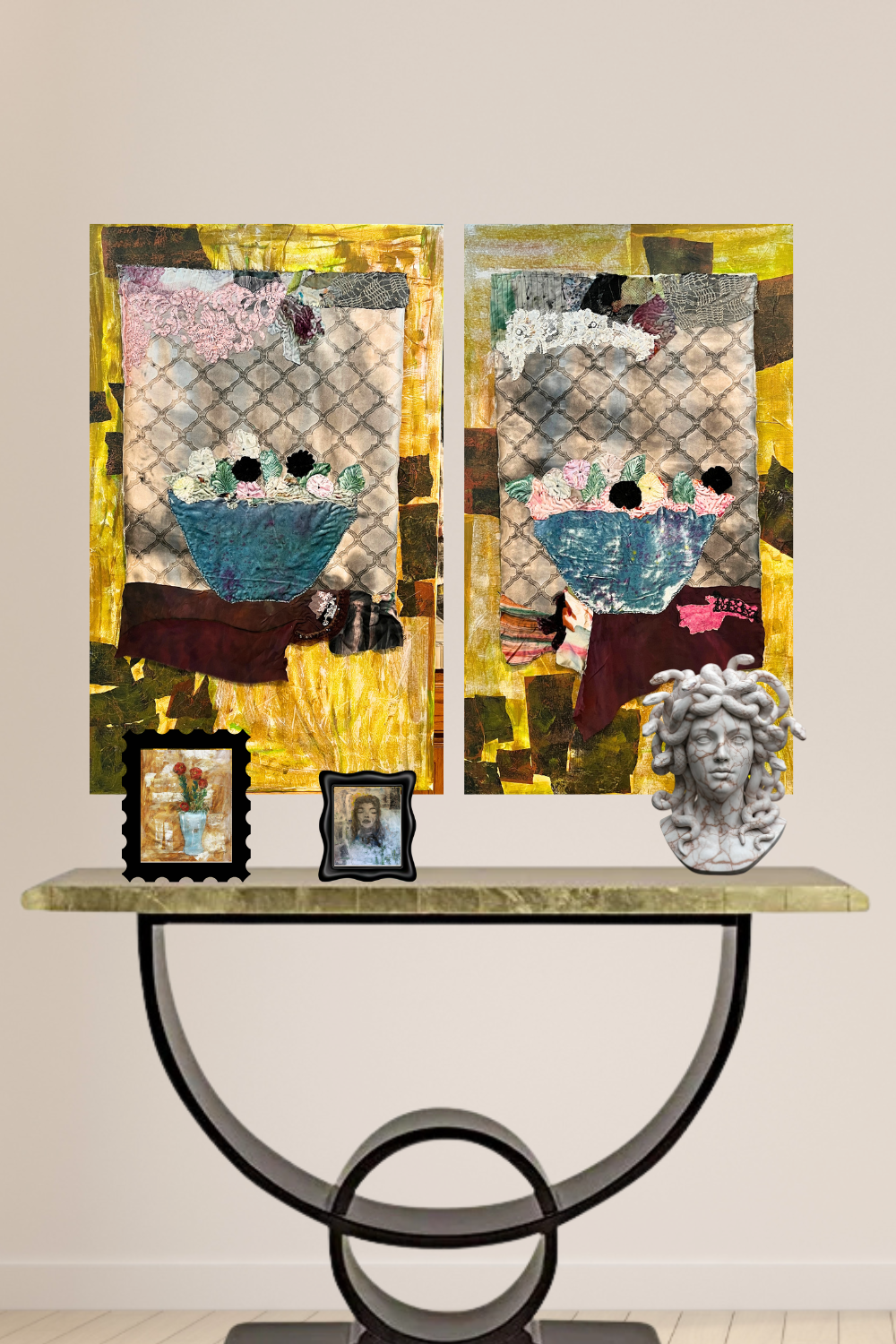 A pair of mixed-media collage wall art panels displayed side-by-side above a console table. The panels feature a whimsical, textured face design with blue, pink, and black elements on a gold and gray background.